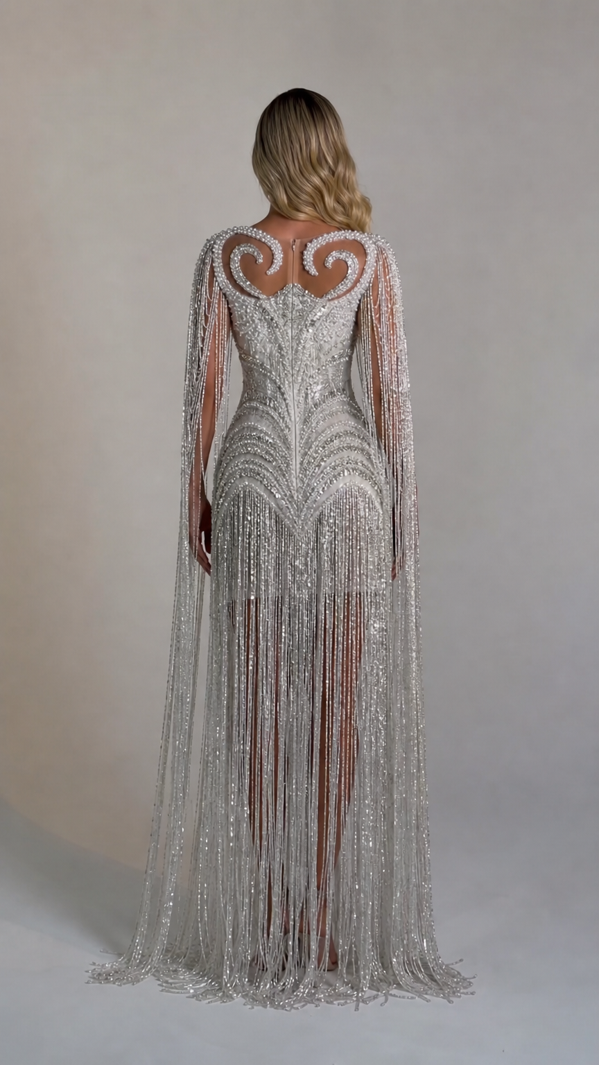 Back view showcasing the flowing cape sleeves and fringe