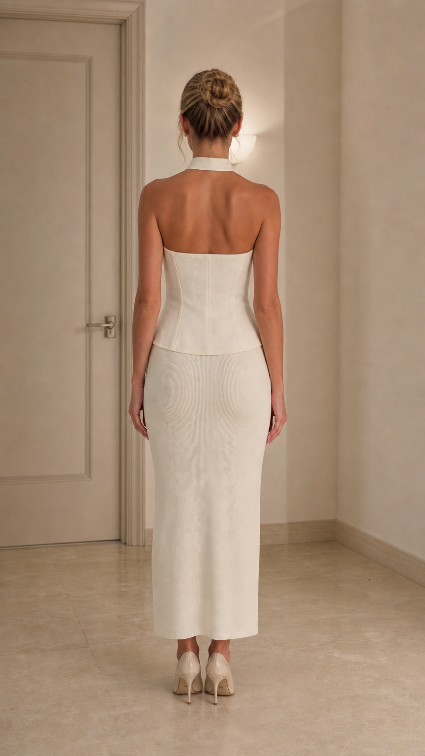Back view of model wearing ivory halter top and midi skirt