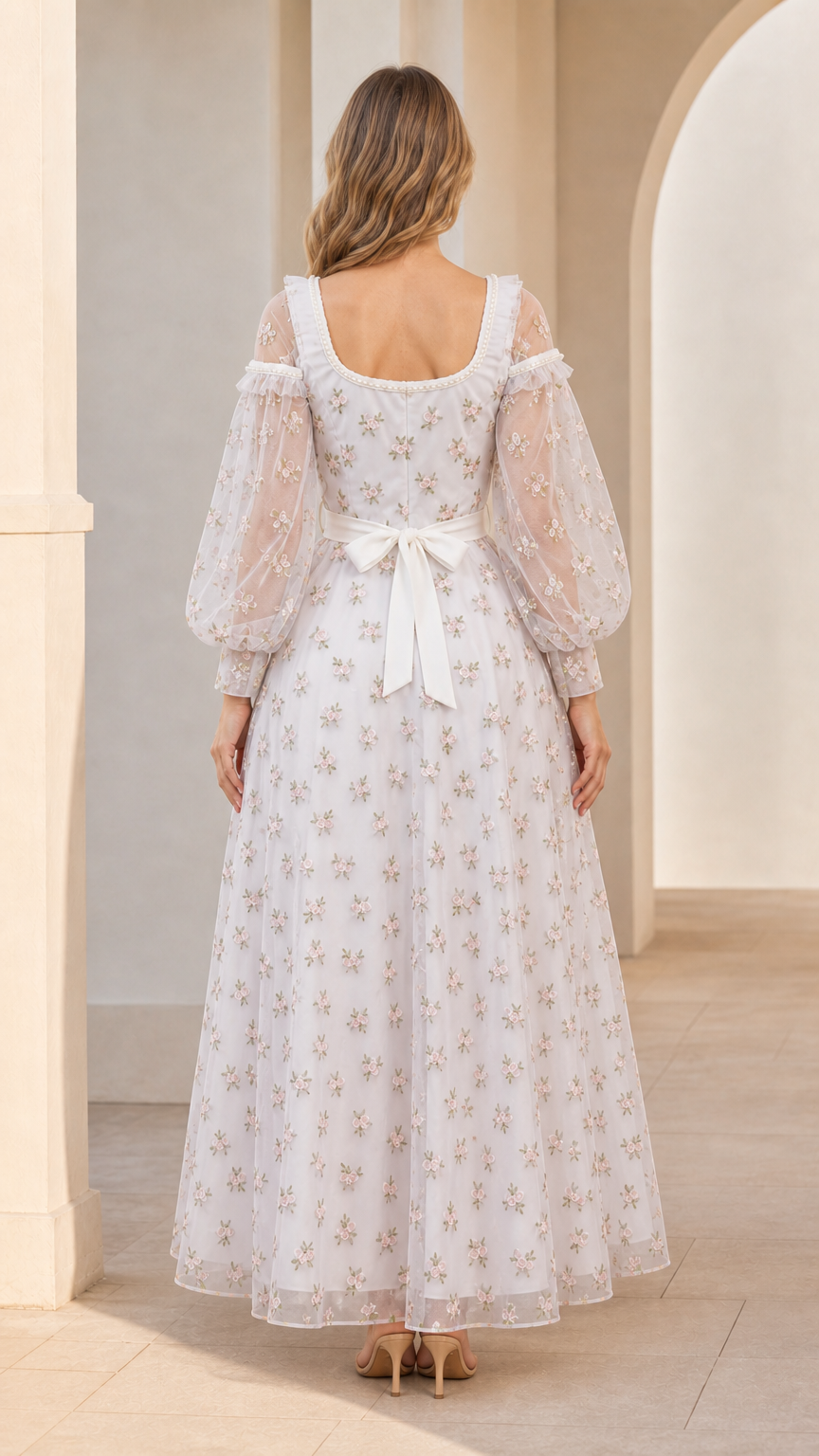 Back view of model showing tie-back sash on white embroidered evening dress
