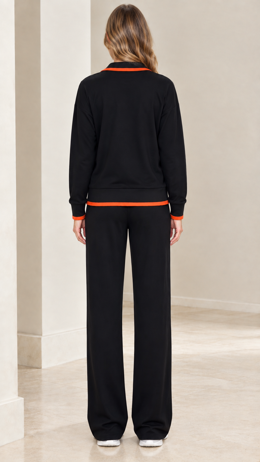 Back view of model wearing black zip-up tracksuit set