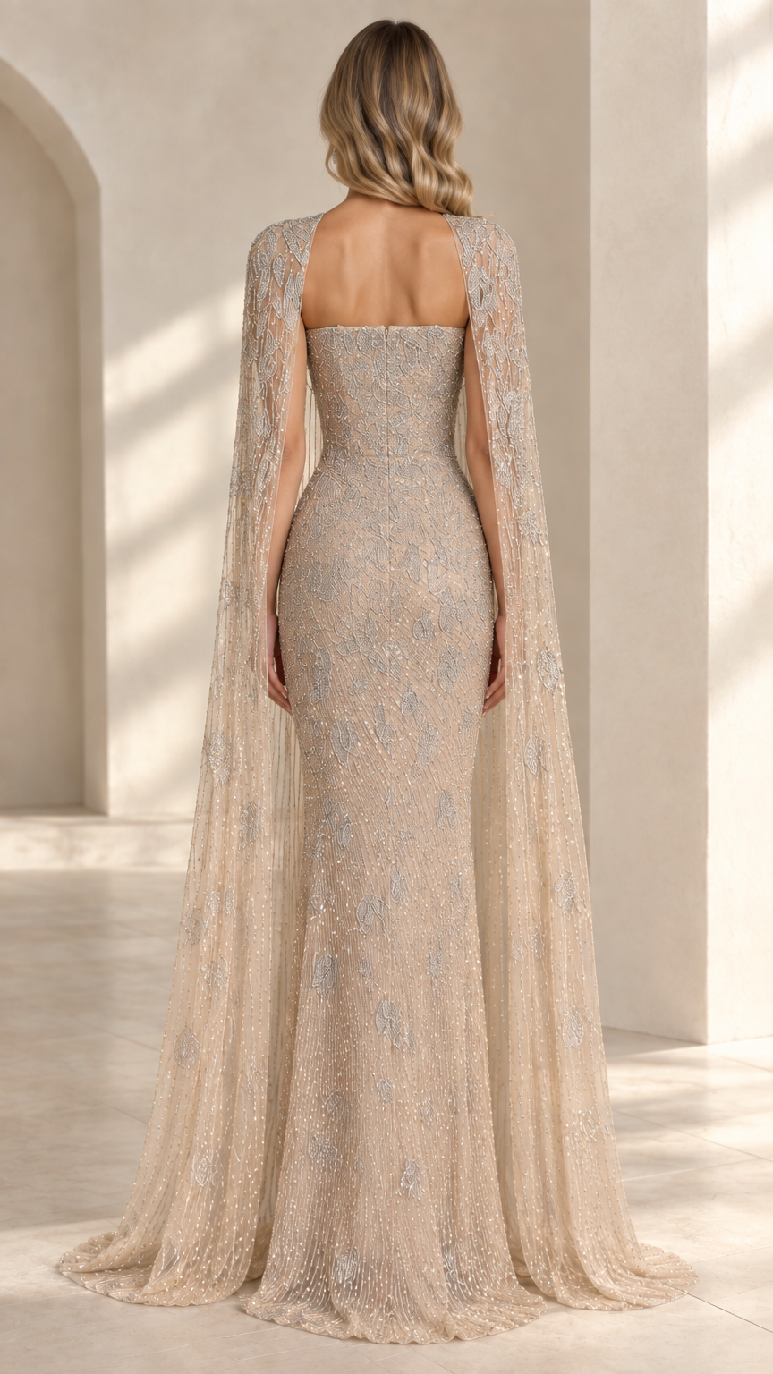 Back view of model wearing champagne strapless evening gown with long cape
