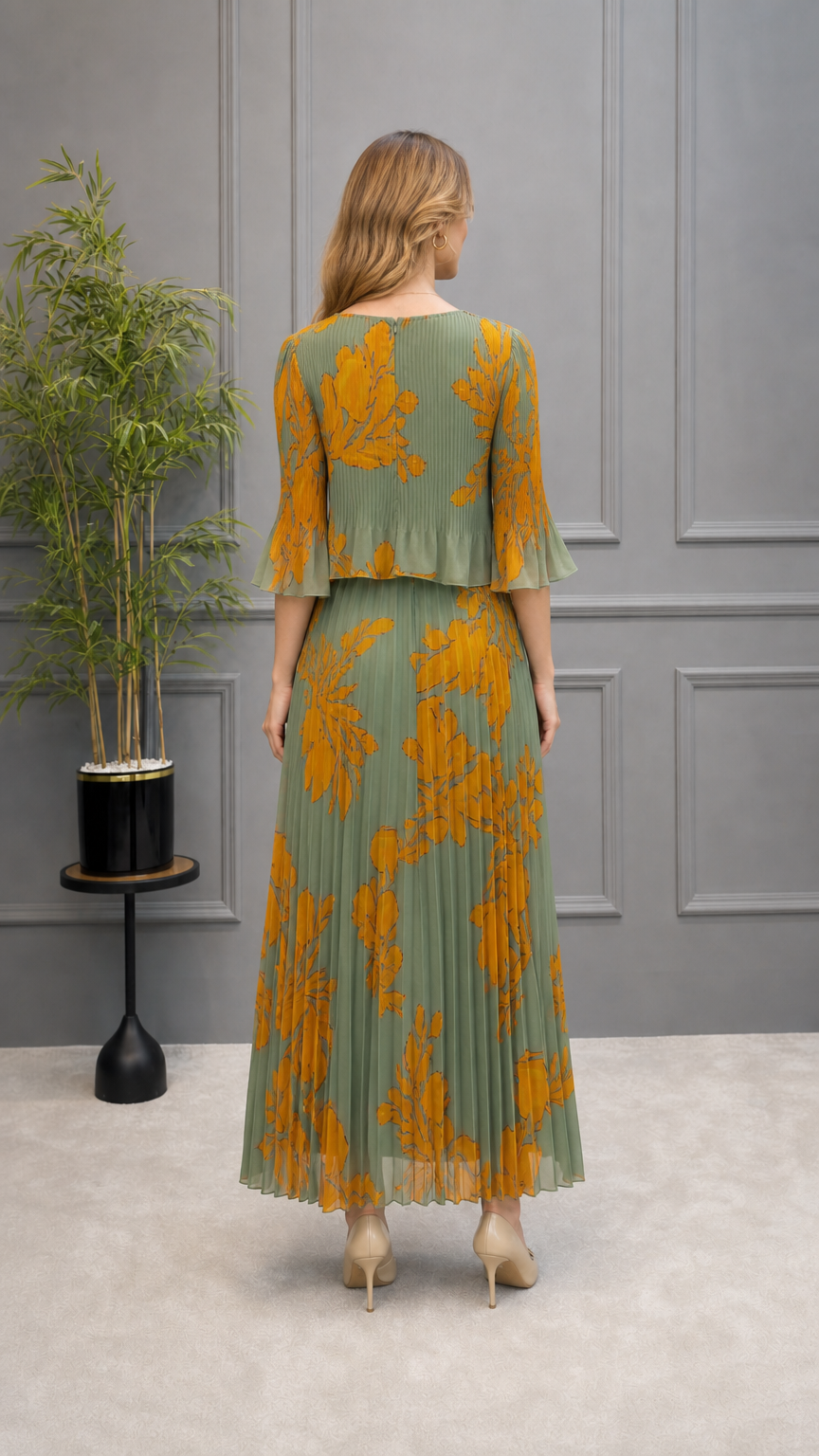Back view of model wearing sage green floral pleated maxi dress with overlay bodice