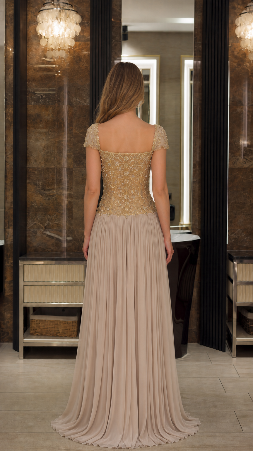 Back view of model wearing the Champagne beaded illusion back pleated formal dress