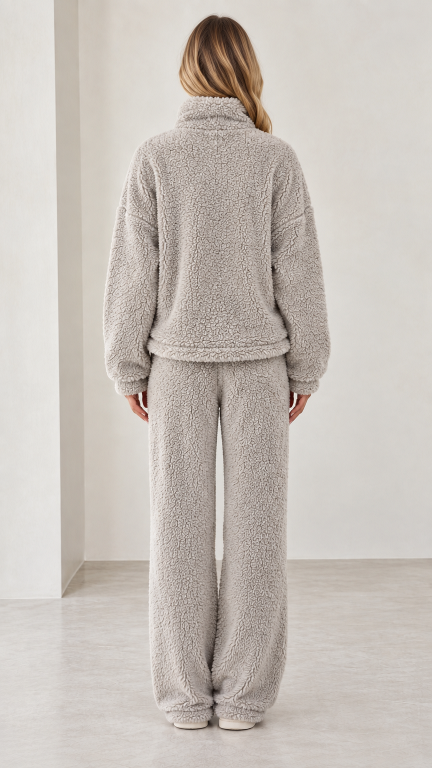 Back view of model wearing light gray fleece pullover and wide-leg pants