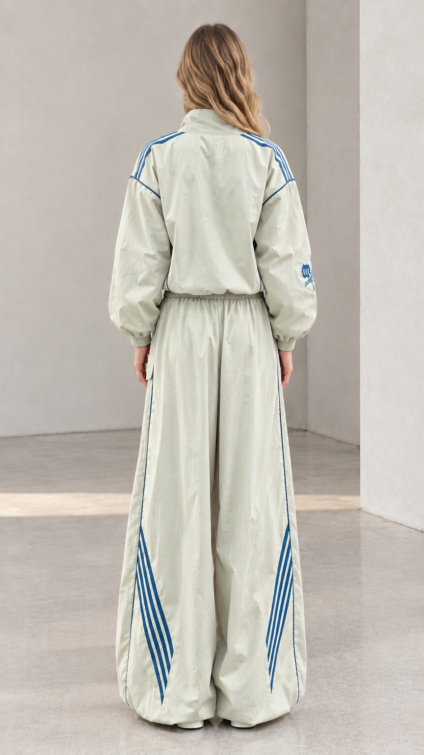 Back view of woman showing the relaxed fit and stripe details of the sage green tracksuit set