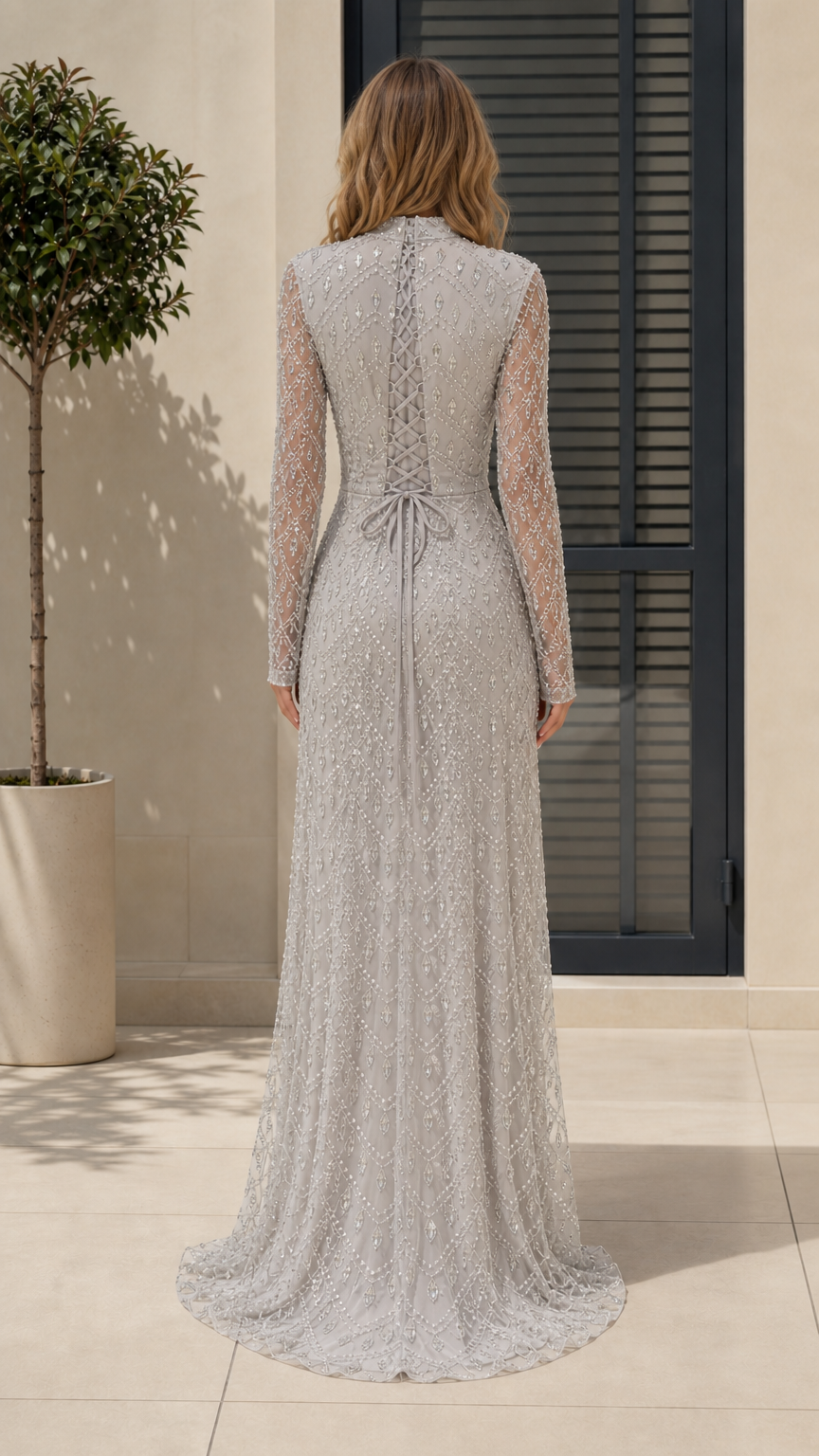 Back view of model showing lace-up detail on silver evening gown