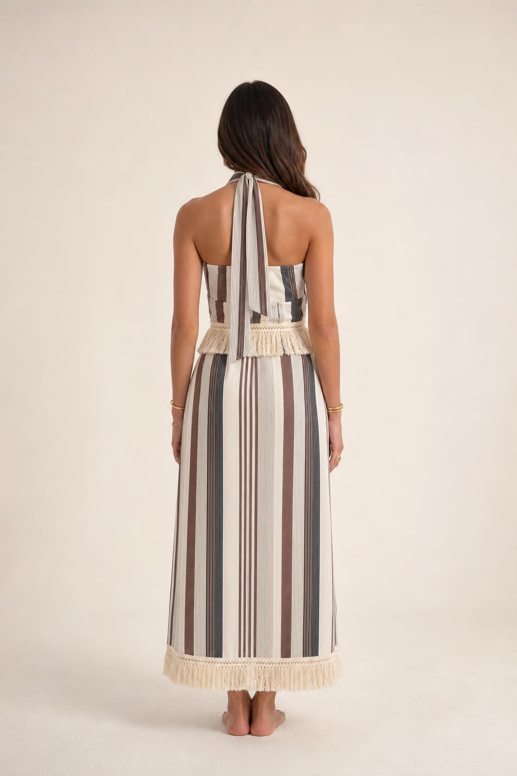 Back view of model wearing beige stripe halter fringe maxi dress