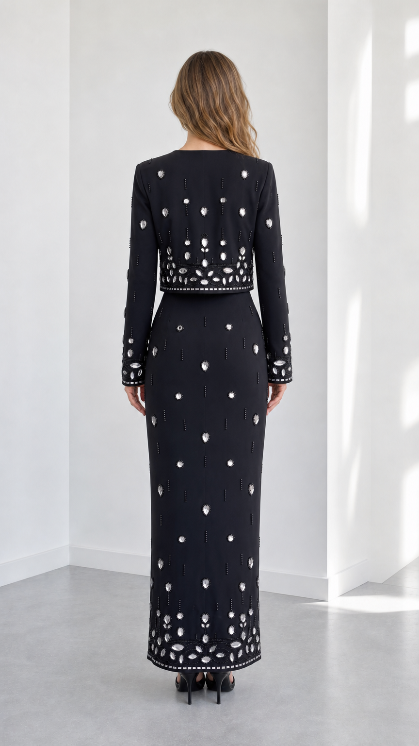 Back view of black rhinestone embellished two-piece evening set showing column skirt