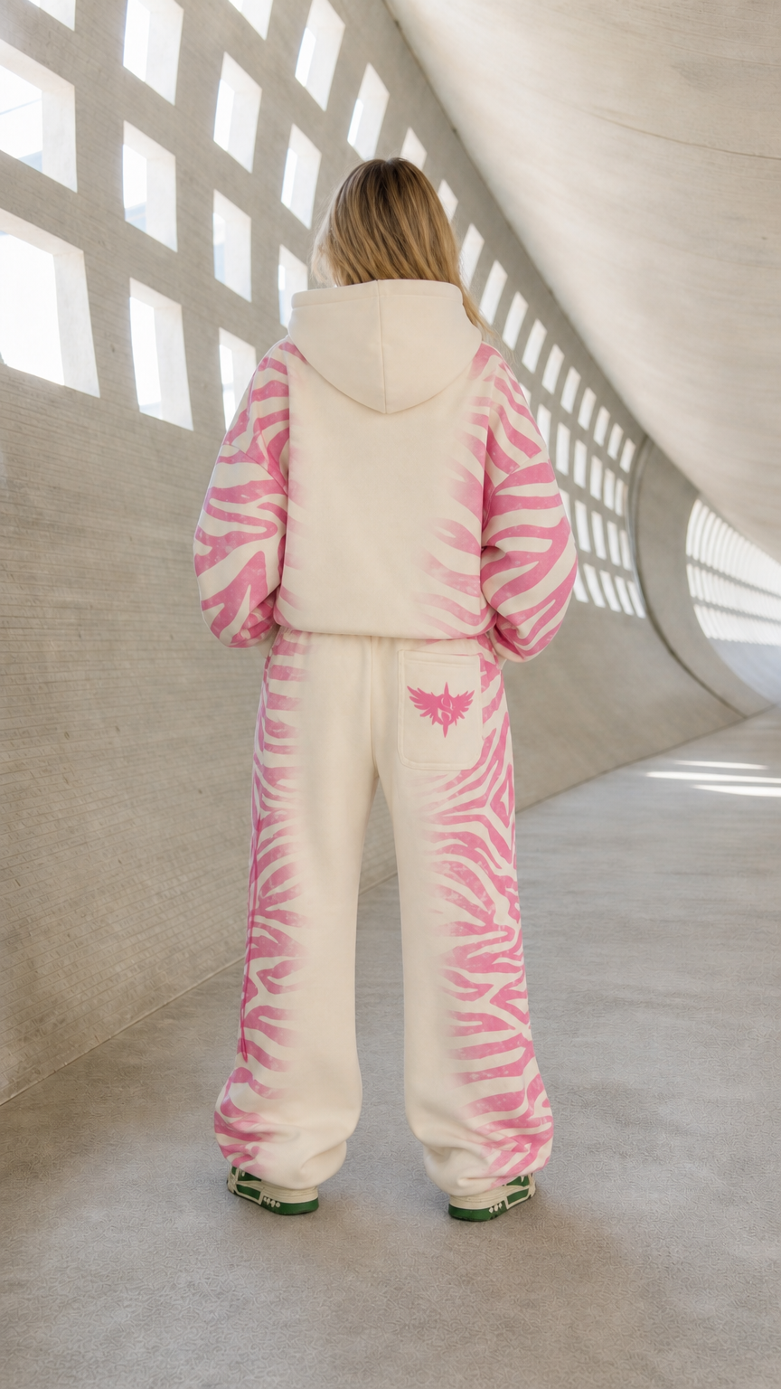 Back view of model wearing cream and pink two-piece oversized tracksuit set