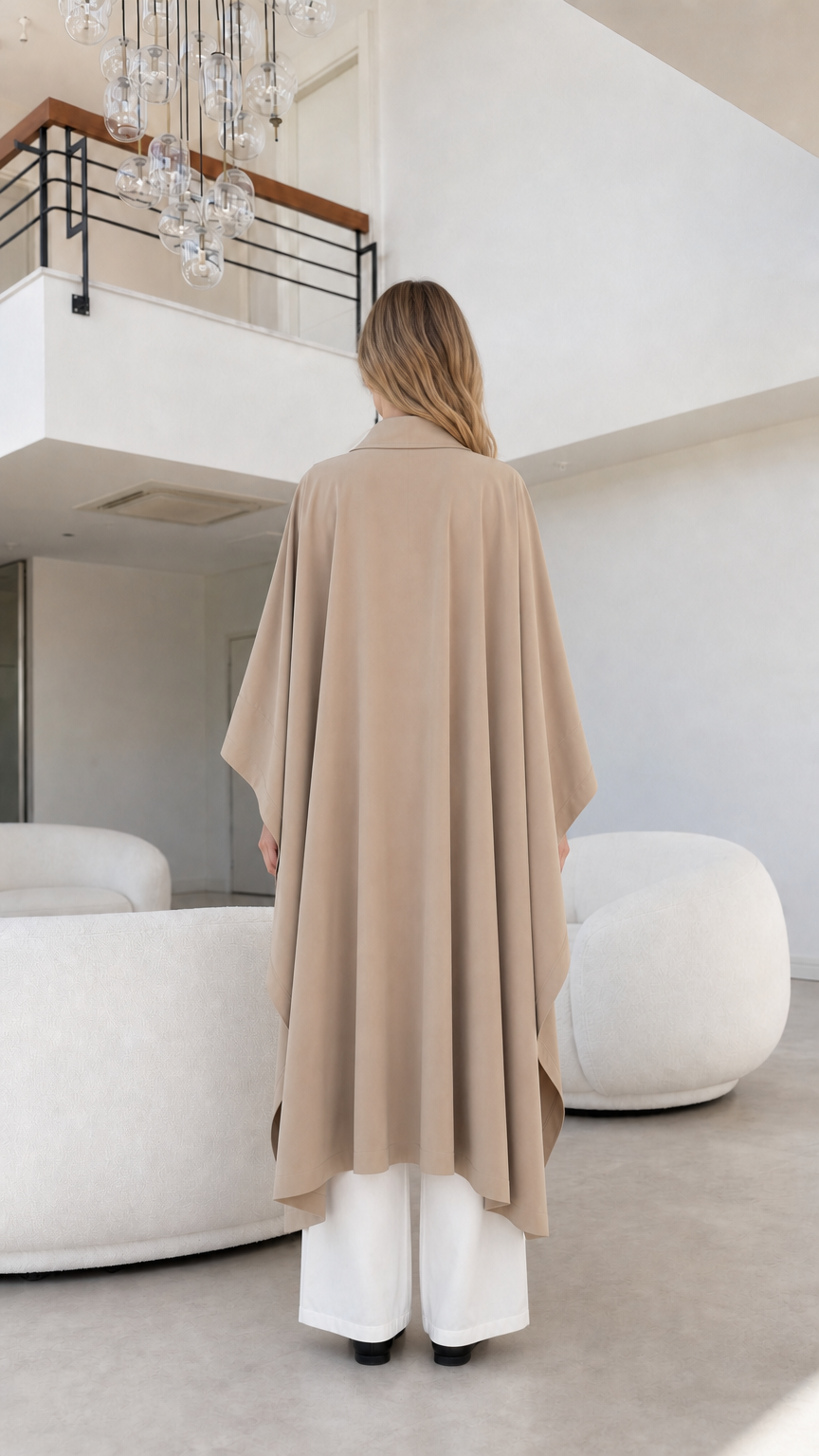 Full back view of beige draped longline cape coat showing fluid movement