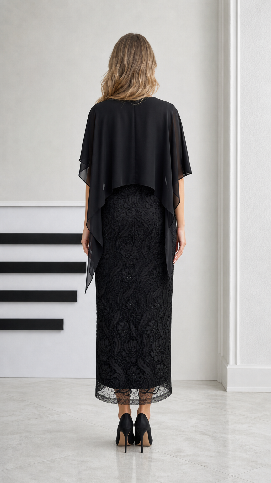Back view of black midi dress showing chiffon capelet draping