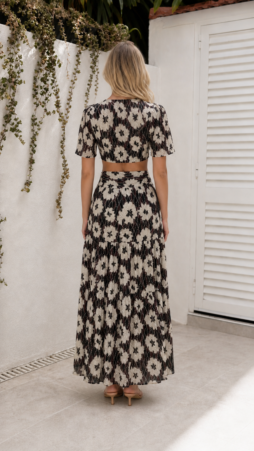 Back view of model wearing black floral cutout maxi dress