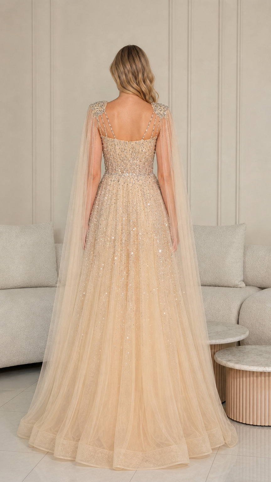 Back view of champagne floor-length evening gown showing flowing tulle cape