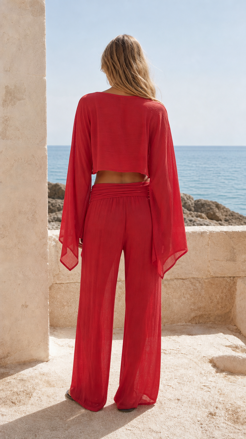Back view of woman wearing red matching crop top and trousers