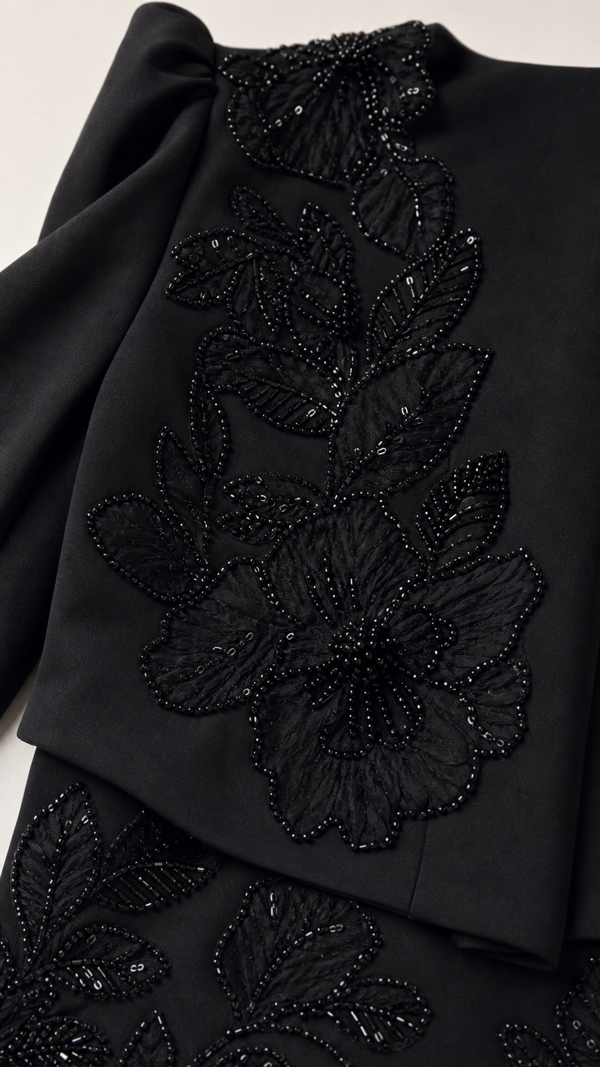Close-up detail of black beaded floral lace embroidery on bodice and skirt