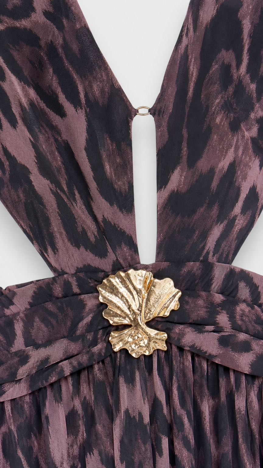 Close-up detail of the plunging neckline, waist cutout, and gold shell hardware