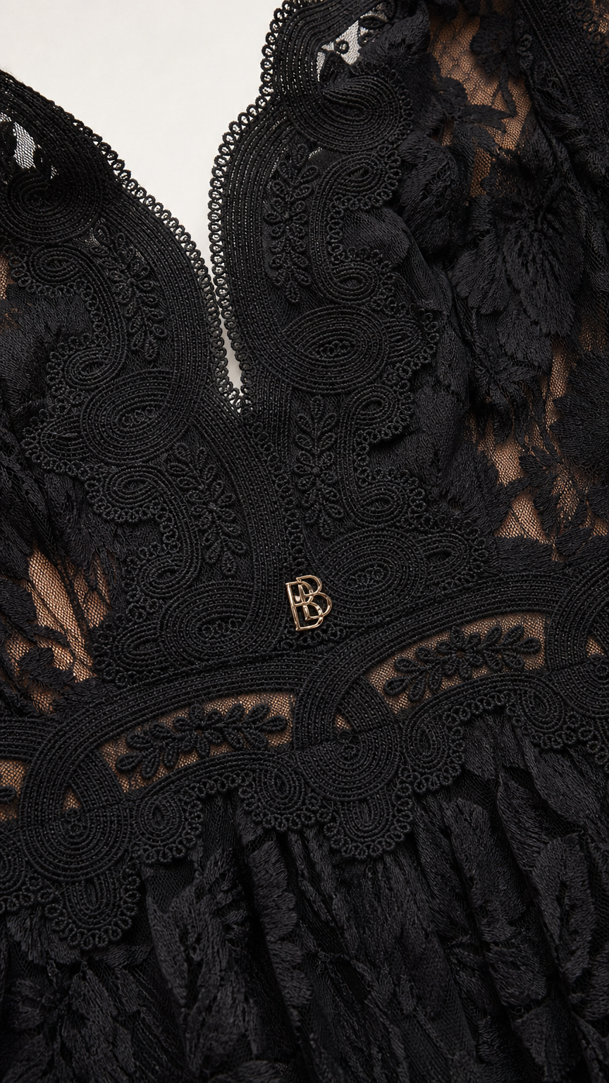Close-up of plunging neckline and hardware detail on black dress