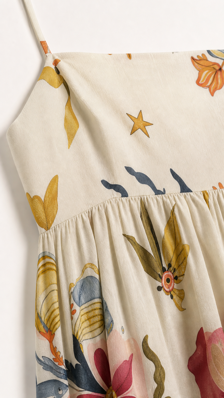 Close-up detail of fabric, print, and straps on cream dress