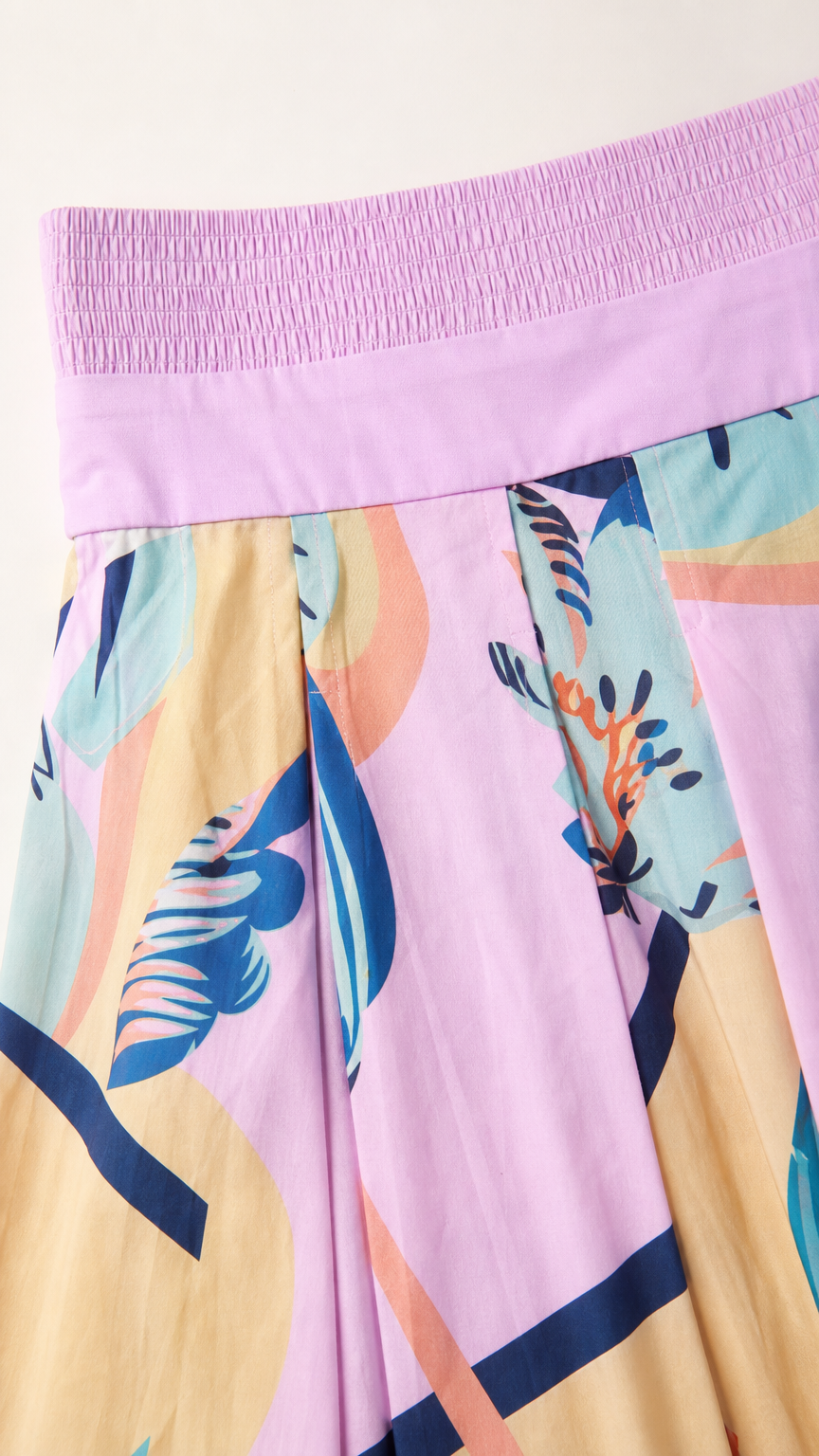 Close-up detail of the pink dress smocked bandeau and abstract pattern