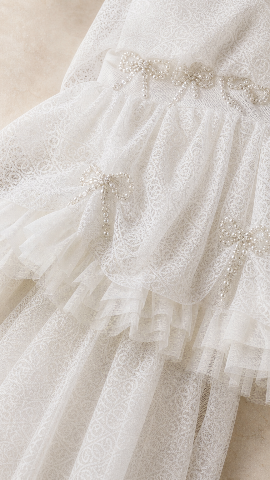 Close-up detail of rhinestone bow embellishments and ruffled lace texture