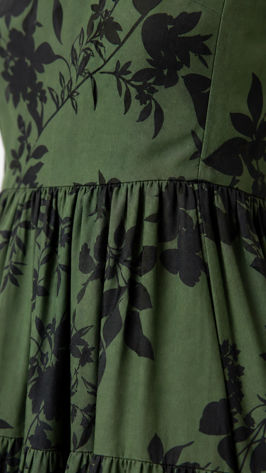 Close up of green floral fabric and tiered skirt detail