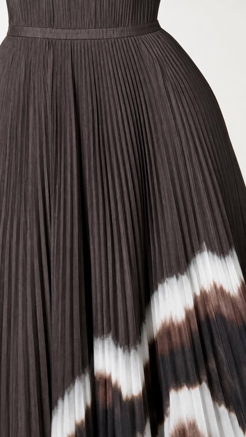 Close-up detail of pleated texture and dip-dye hem on dress