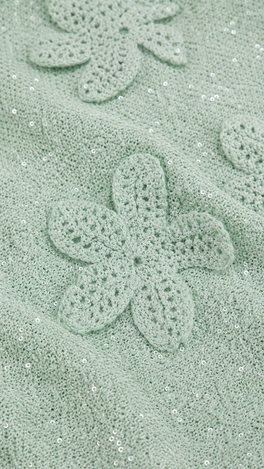 Close-up detail of mint green crochet floral applique and shimmer fabric