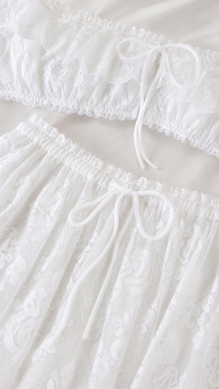 Close-up detail of white lace crop top and skirt drawstring