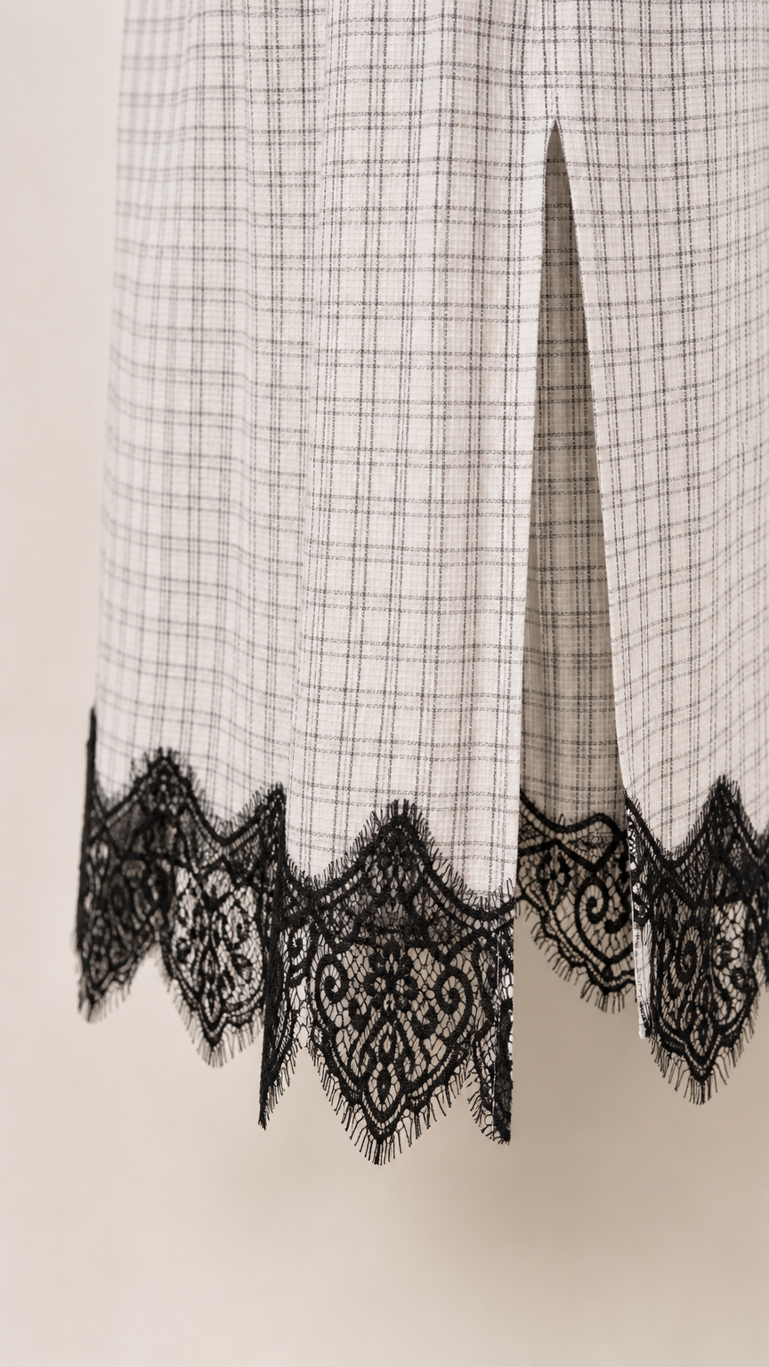 Close-up of lower hem detail showing side slit and scalloped black lace