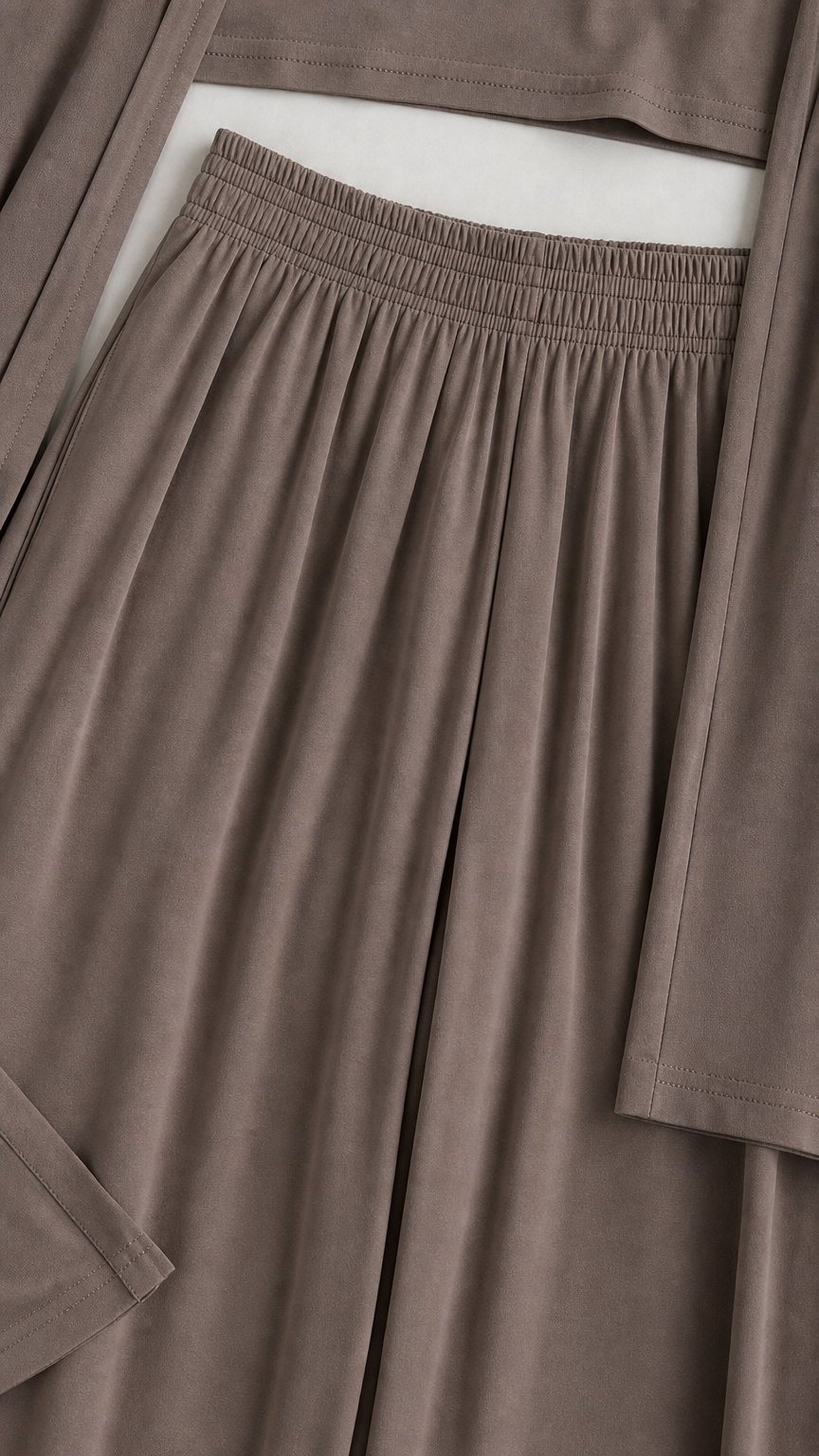 Close-up detail of the gathered elastic waistband, soft fabric texture, and sleeve cuff