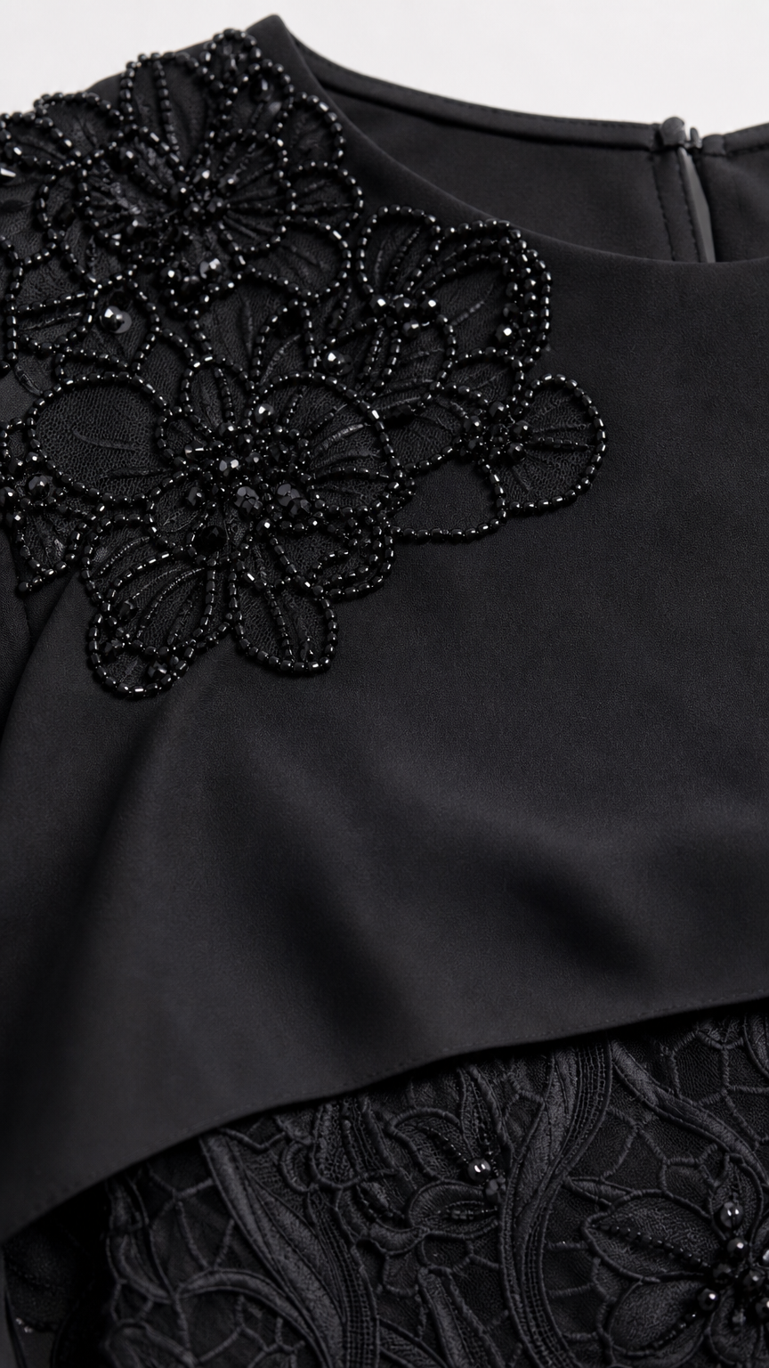 Close-up detail of floral beadwork embroidery on capelet neckline