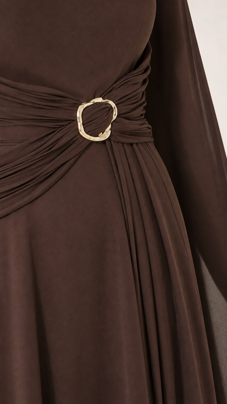 Close-up detail of side waist ruching and gold-tone circular buckle accent