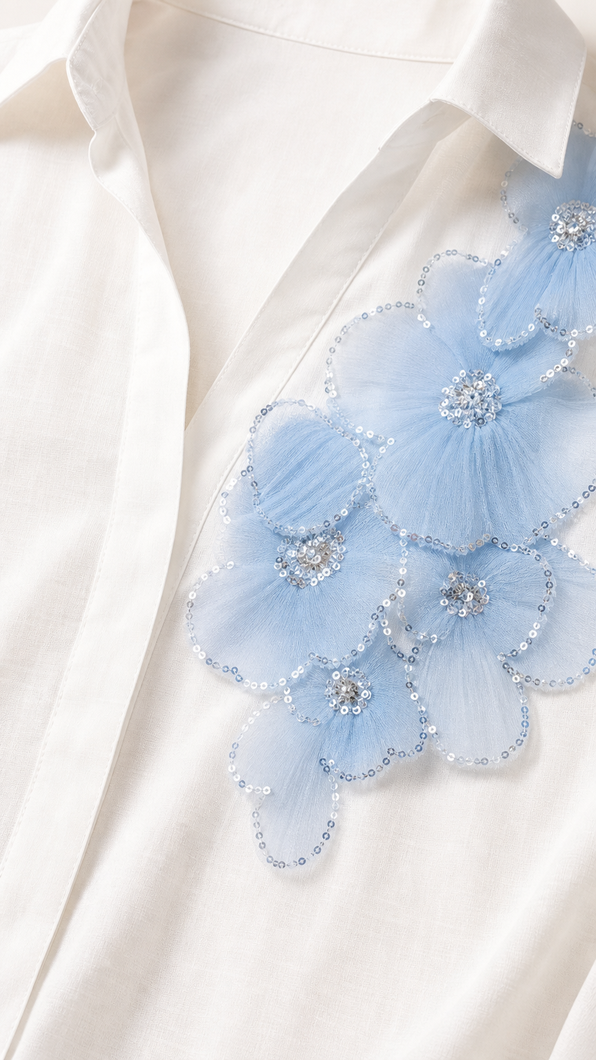 Close-up detail of light blue 3D mesh floral appliqué with sequin and bead embellishments