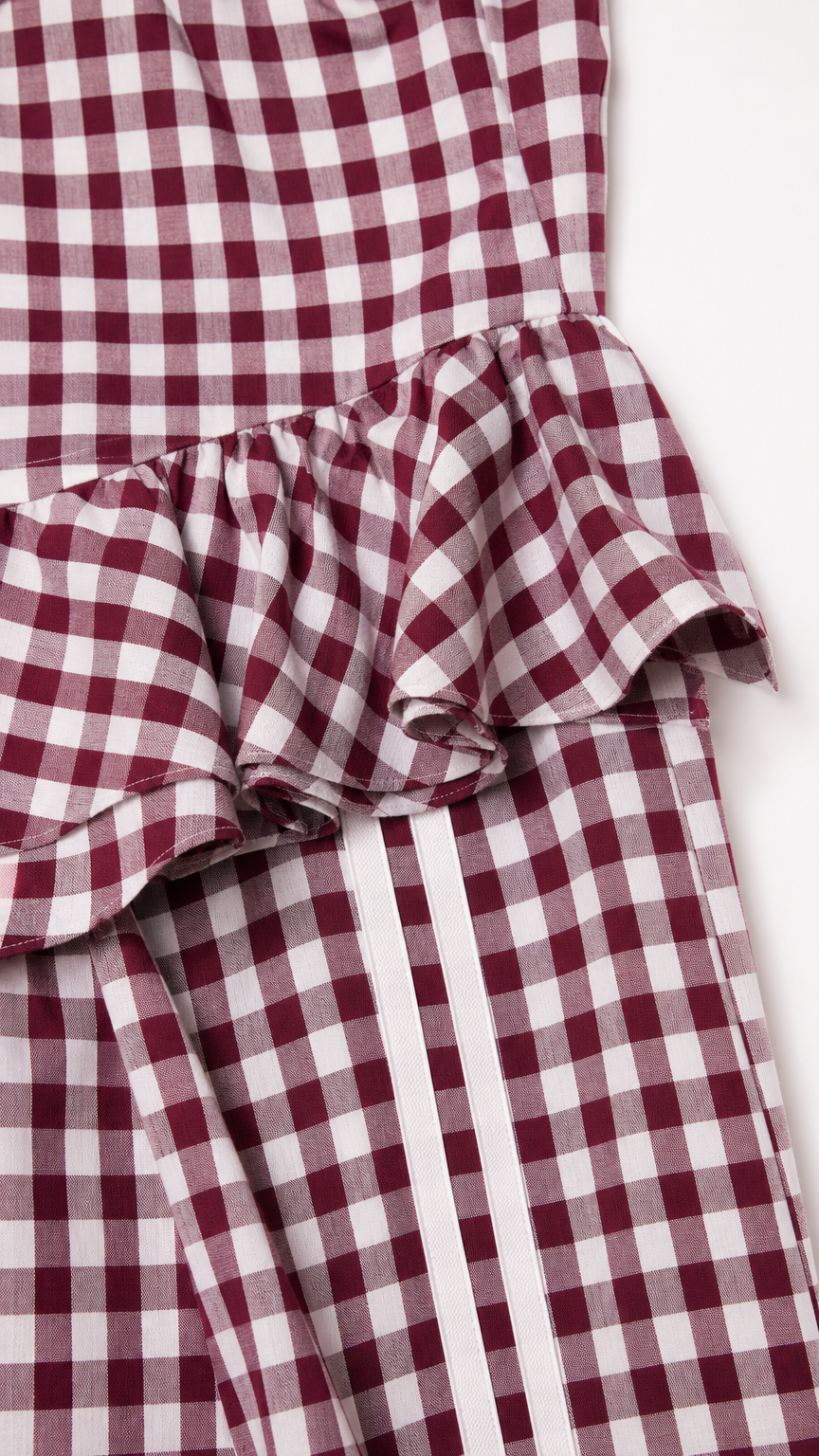 Close-up of peplum ruffle and side stripe detail on burgundy set