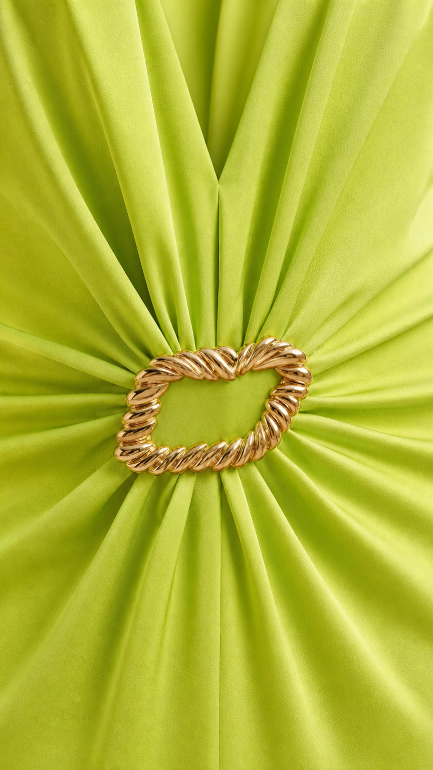 Close-up of gathered satin fabric and twisted gold ring buckle detail on lime green dress