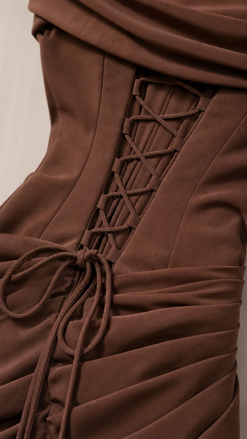 Close-up detail of back corset lace-up and ruching on brown formal dress