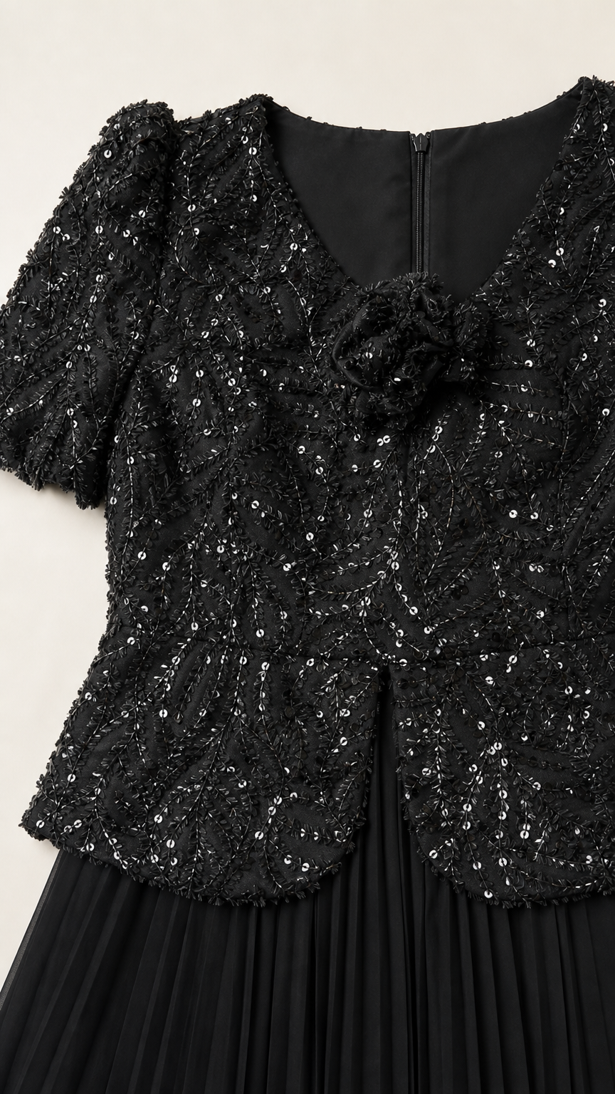 Close-up detail of black sequin bodice with 3D floral rosette and zipper back