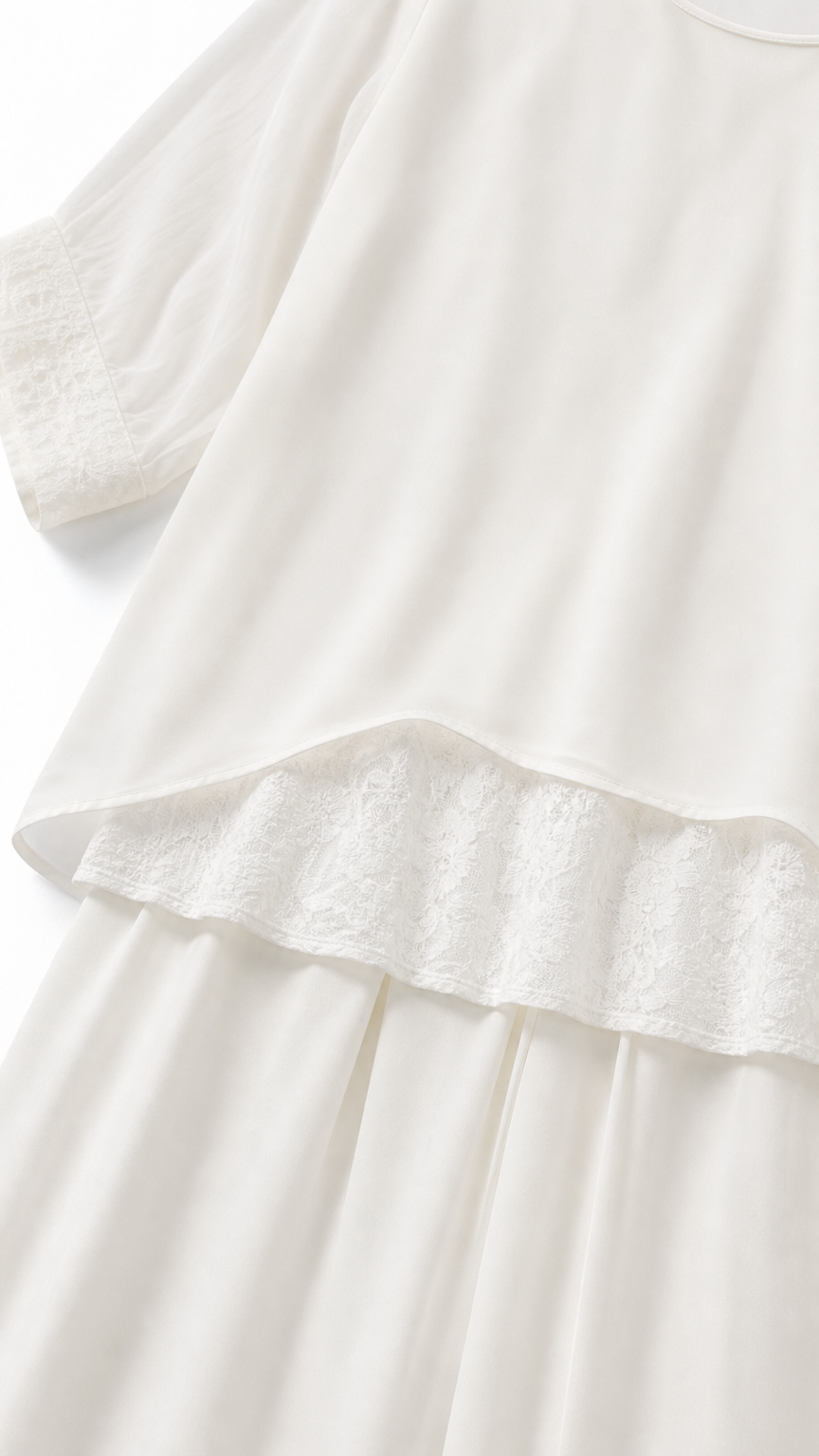 Close-up of white tunic hem with delicate lace trim