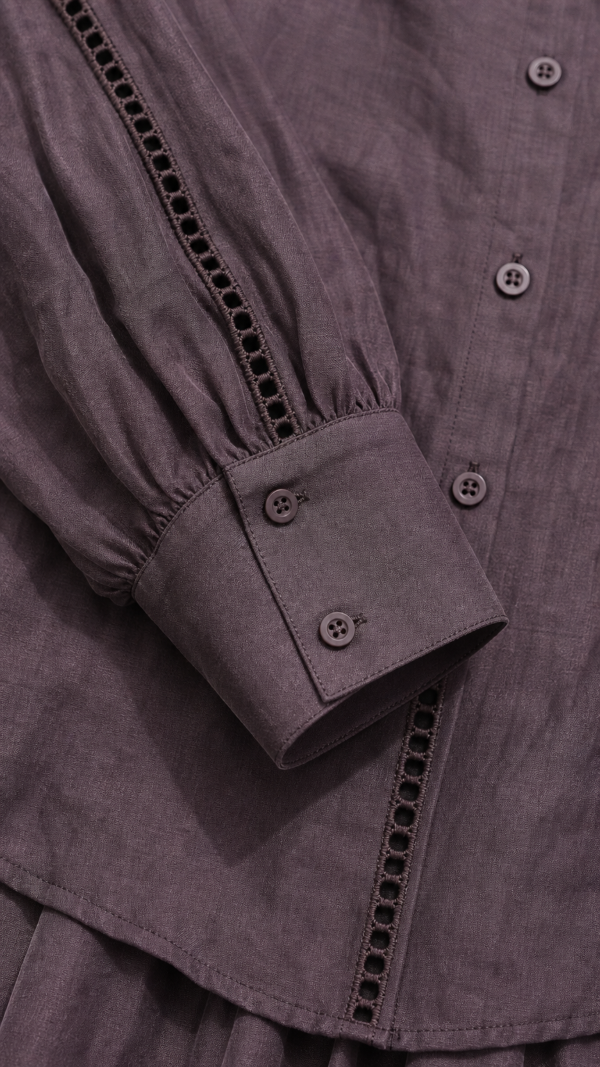 Close-up of blouse button front, decorative trim, and button cuff in mauve