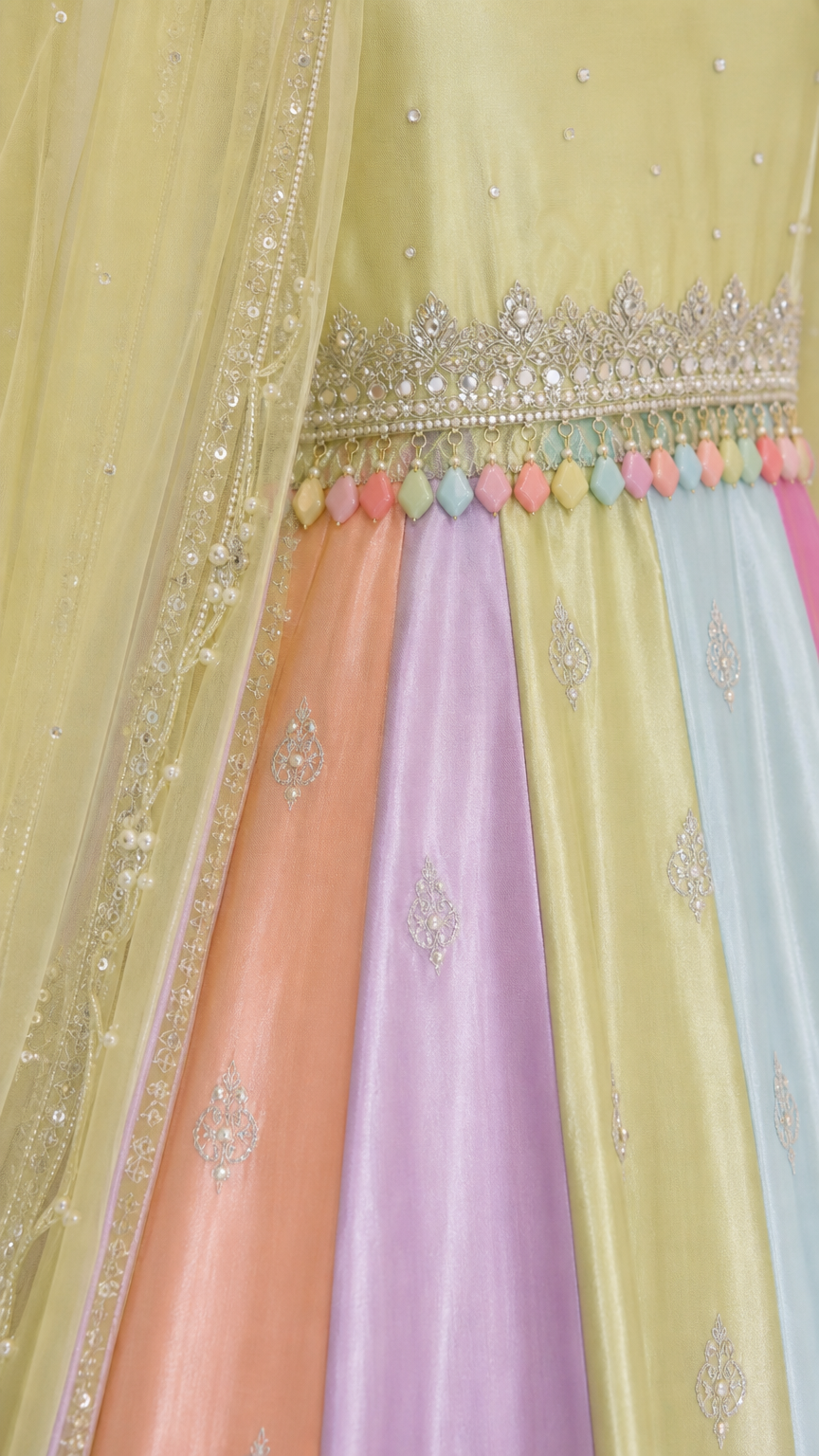 Close-up detail of embroidered waistband with colorful bead fringe and panel fabric