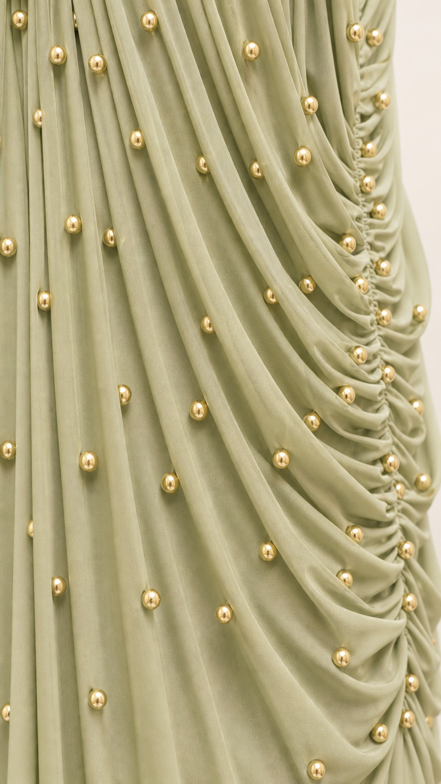 Close up detail of gathered fabric with gold-tone beaded embellishments