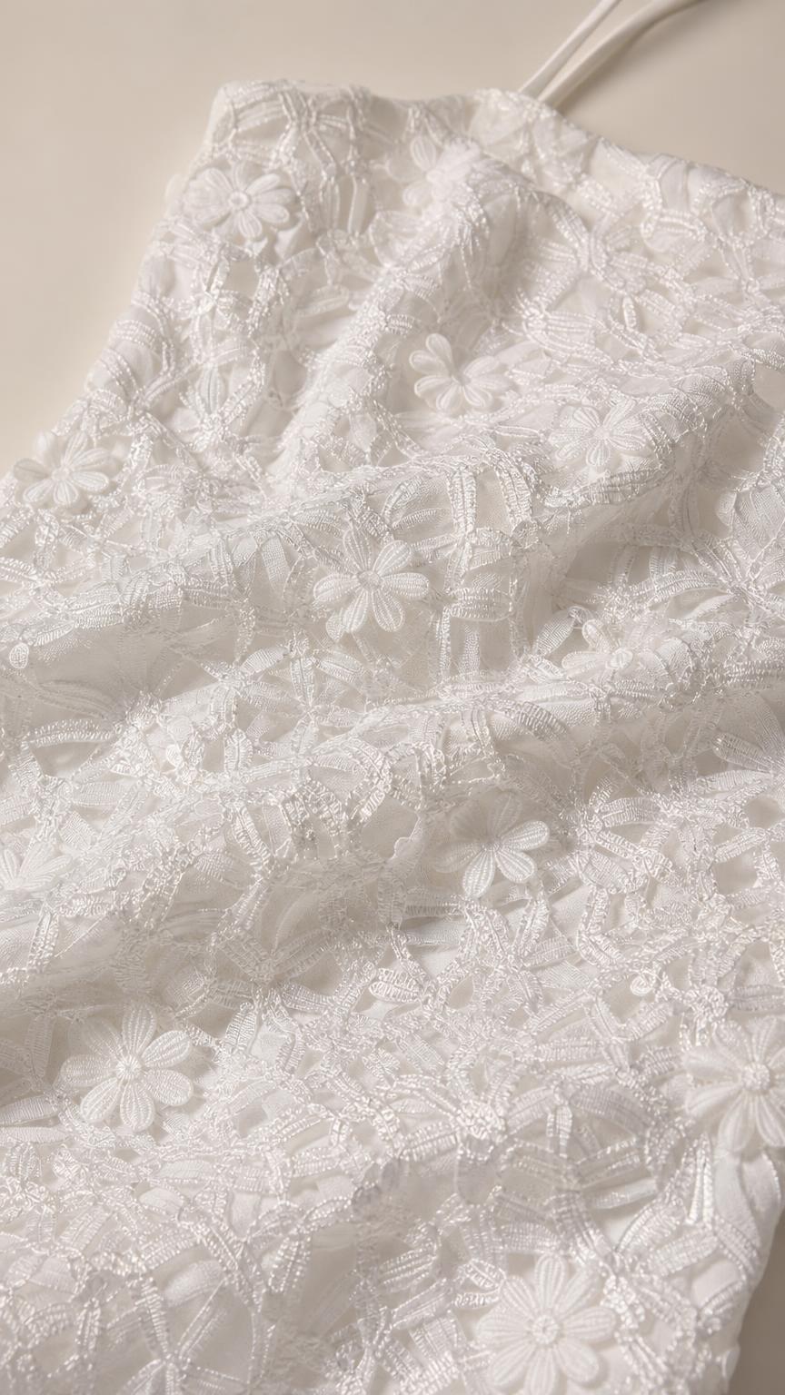 Close-up detail of white 3D floral lace fabric