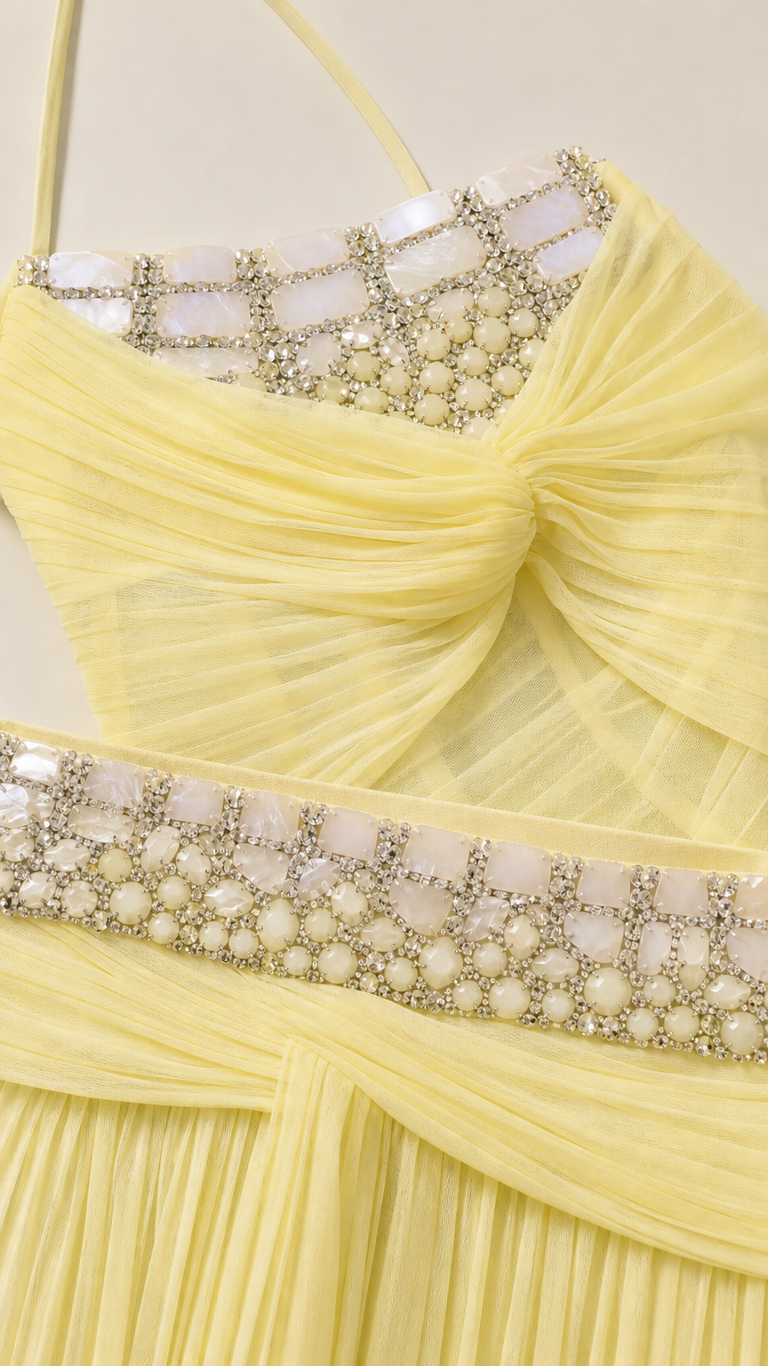 Close-up detail of rhinestone and pearl embellishments on the yellow corset and waistband