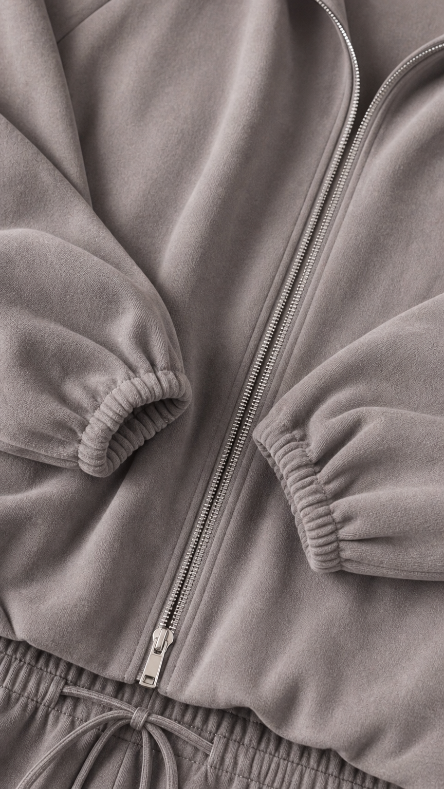 Close-up detail of grey soft fleece fabric, sturdy zipper, and gathered elastic cuffs