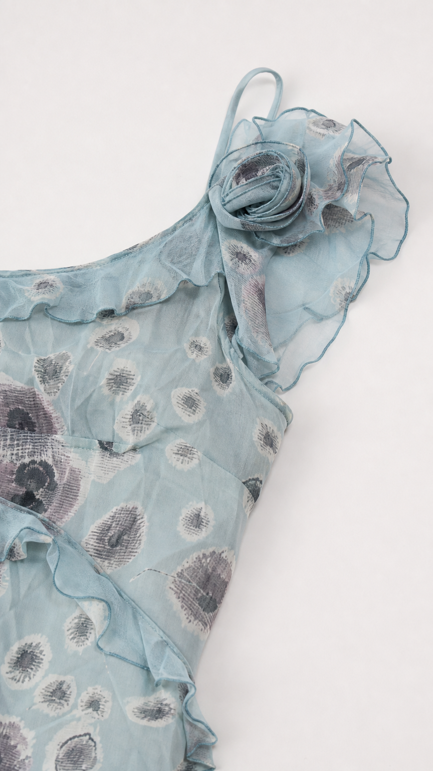 Close-up detail of 3D rosette and ruffle trim on dusty blue floral fabric