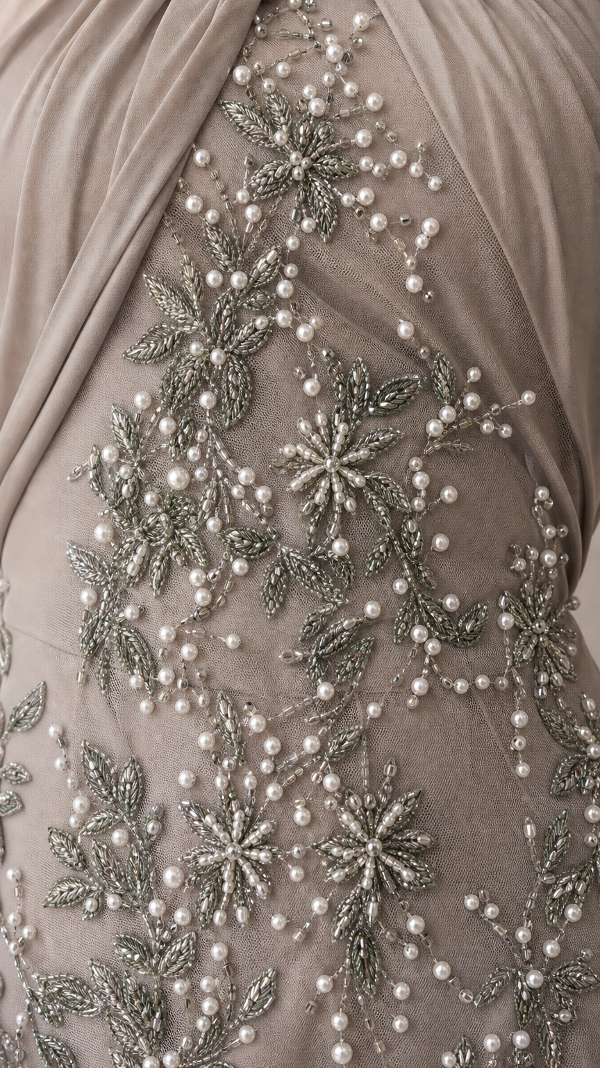 Close-up detail of delicate pearl and silver bead floral embroidery on mesh fabric