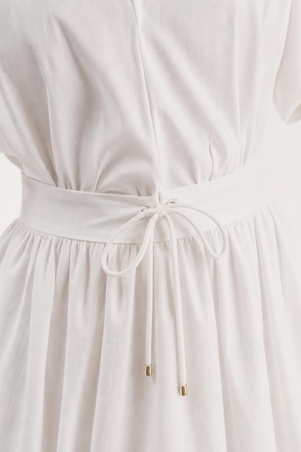Close-up of drawstring waist detail on white mini dress