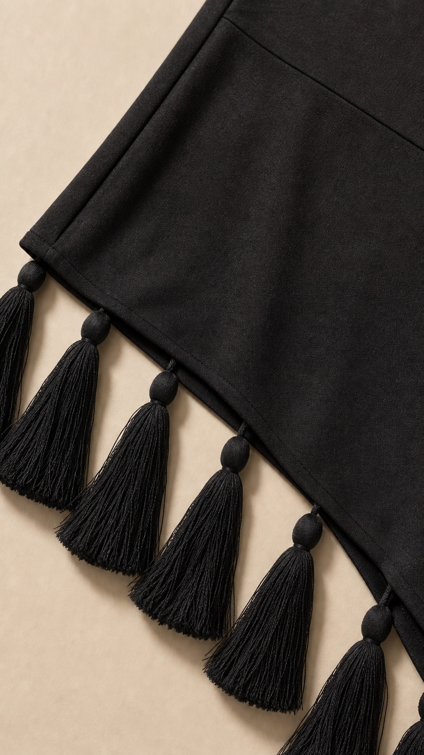 Close-up of asymmetrical tassel hem detail