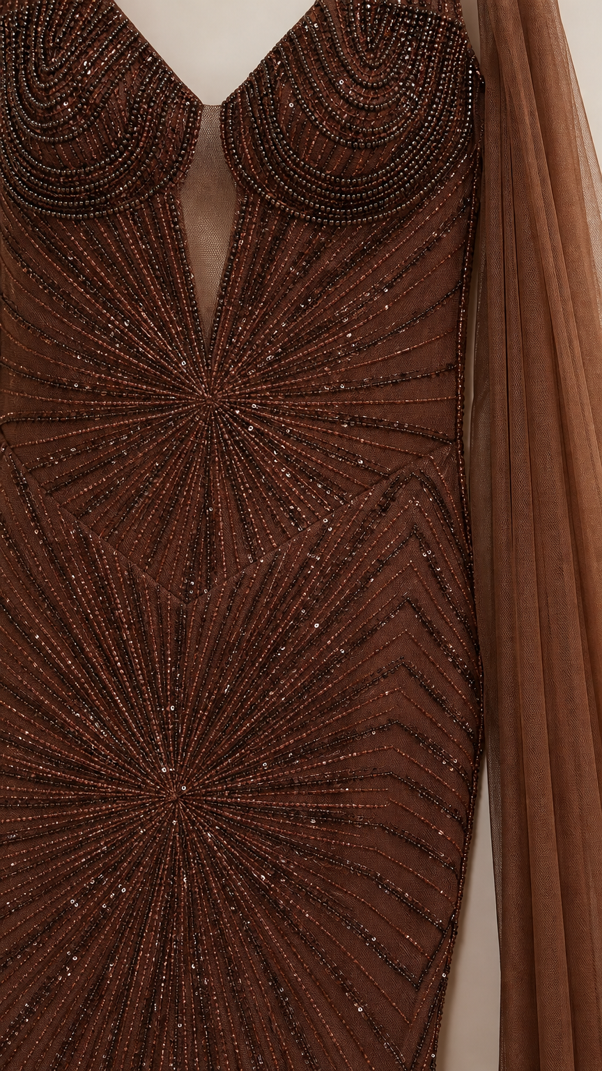 Close-up of intricate sunburst beadwork and sheer neckline on brown gown