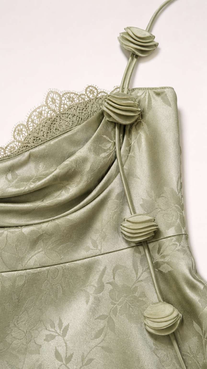 Close-up of rosette strap and lace detail on sage green dress
